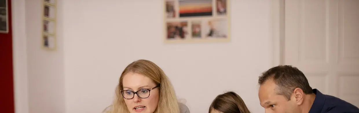 Pierwsza część zdjęcia z dzieckiem i rdzicami wspólnie siedzących przy stole - przedszkole Kraków